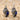 Lapis Spiral Shell Earring, oxidized silver, product photo on sand