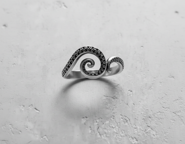 Front view of handcrafted silver octopus ring showing detailed tentacle suckers and curling spiral shape