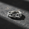 Front view of oxidized silver frog prince ring showcasing detailed eyes and mouth on dark stone