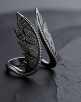 Side profile of handcrafted silver ring featuring detailed feather carving and open band