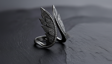 Side profile of handcrafted silver ring featuring detailed feather carving and open band