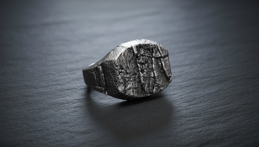 Close-up detail of textured metalwork on silver grunge ring showing realistic rock fissures and organic shape design