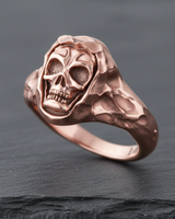 Detailed view of rose gold skull ring with hood detail showing intricate facial carving and side profile