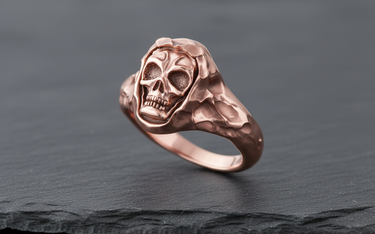 Detailed view of rose gold skull ring with hood detail showing intricate facial carving and side profile