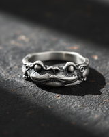 925 sterling silver frog prince ring with oxidized finish displayed on dark textured stone background
