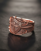 Rose gold vermeil cross ring with detailed beaded borders on dark stone background