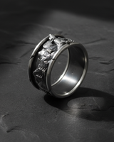 Side angle of handcrafted silver mountain ring displaying detailed pine tree and rock texture
