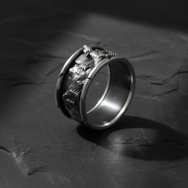 Side angle of handcrafted silver mountain ring displaying detailed pine tree and rock texture