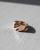 Close-up of textured signet ring highlighting organic rock formation design and metal thickness