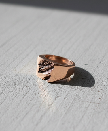 Close-up of textured signet ring highlighting organic rock formation design and metal thickness