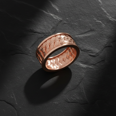 Rose gold tone dragon skin ring with textured surface pattern and comfortable fit design on slate