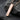 Close-up of geometric rose gold plated equality bar pendant resting on dark textured stone background
