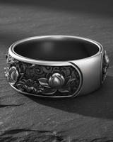 Close-up of Japanese ornamental design on handcrafted silver ring band against textured background