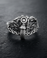 Angled view of silver biker ring showing intricate wing details and mechanical chain link band