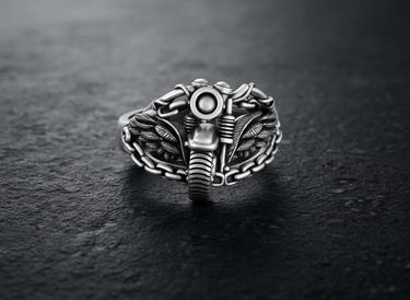 Angled view of silver biker ring showing intricate wing details and mechanical chain link band