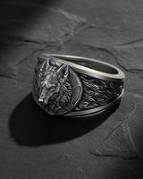 Angled shot of handcrafted silver wolf ring showing intricate fur texture and crescent moon details on the band