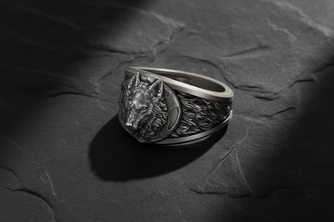 Angled shot of handcrafted silver wolf ring showing intricate fur texture and crescent moon details on the band