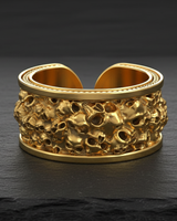 Gold vermeil skull cuff ring featuring a wide band of densely packed skulls on dark textured background