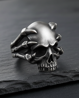 Side profile of gothic silver skull ring showing intricate bone talons and oxidized finish for depth and contrast