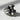 Angled side view of silver skull ring showing thick band, intricate baroque details, and silenced skull design
