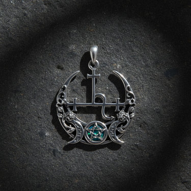 Top-down view of silver triple moon goddess necklace showing intricate Lilith symbol and blue opal inlay protection amulet