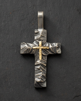 Top down view of two tone silver cross pendant highlighting sturdy bail and detailed rock texture design