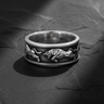 Side view of charging bull relief carved into a 925 sterling silver ring band on dark texture
