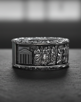Side view of silver religious wedding band displaying temple architecture and floral rim details on dark stone