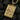 Gold-tone variant of the King of Clubs playing card pendant displaying detailed relief work on a dark textured background