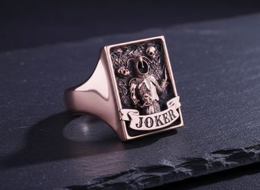 Side perspective of rose gold plated Joker signet ring highlighting thick band and detailed relief engraving