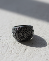 Front view of handcrafted silver Yggdrasil ring featuring Tree of Life design on textured black rhodium background