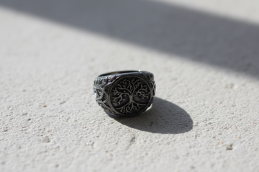 Front view of handcrafted silver Yggdrasil ring featuring Tree of Life design on textured black rhodium background
