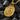 Gold tone skull crown pendant displayed on black charcoal showing intricate regal crest details and relief