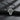 Back view of silver orthodox cross pendant showing engraved prayer text and polished finish on stone surface