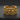 Gold vermeil skull cuff ring featuring a wide band of densely packed skulls on dark textured background