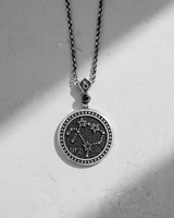 Reverse side of silver zodiac pendant featuring Ophiuchus constellation stars and symbols