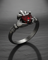 Oxidized 925 sterling silver Claddagh ring featuring a red heart gemstone and crown detail on dark background
