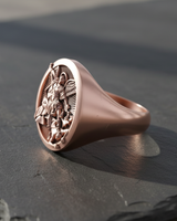 Rose gold St Michael signet ring angled to show the detailed craftsmanship of the wings and armor.