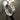 3D render of a geometric silver ring showing the segmented construction and brushed metallic texture on a reflective surface.