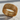 Close-up of geometric band ring resting on stone highlighting the intricate cross-shaped interior cutouts