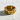Detailed view of the geometric brick ring resting on a textured surface highlighting the woven band