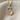 Detailed close-up of the two-tone mother baby footprint pendant resting elegantly on soft, textured fabric.