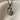 Mother Baby Footprint Pendant, black rhodium, front view on textured fabric