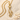 Gold vermeil elegant cat pendant resting on fine white sand with small seashells, highlighting intricate craftsmanship
