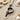 Oxidized silver Bird Letter P Pendant resting on natural sand with seashells, displaying the dark antique finish and depth