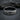 Close-up macro of oxidized silver Sapphic ring resting on textured dark grey stone highlighting deep engraved typography