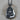 Intricately detailed sterling silver Buddha hand pendant resting flat on a natural wooden background