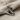 Close-up of handcrafted hockey skate pendant resting on textured fabric showcasing the polished blade and boot