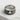 Close-up of the 925 sterling silver card club ring resting on white stone emphasizing the dark oxidized texture
