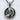 Detailed view of the oxidized silver mother and child pendant resting on a textured white surface showing craftsmanship
